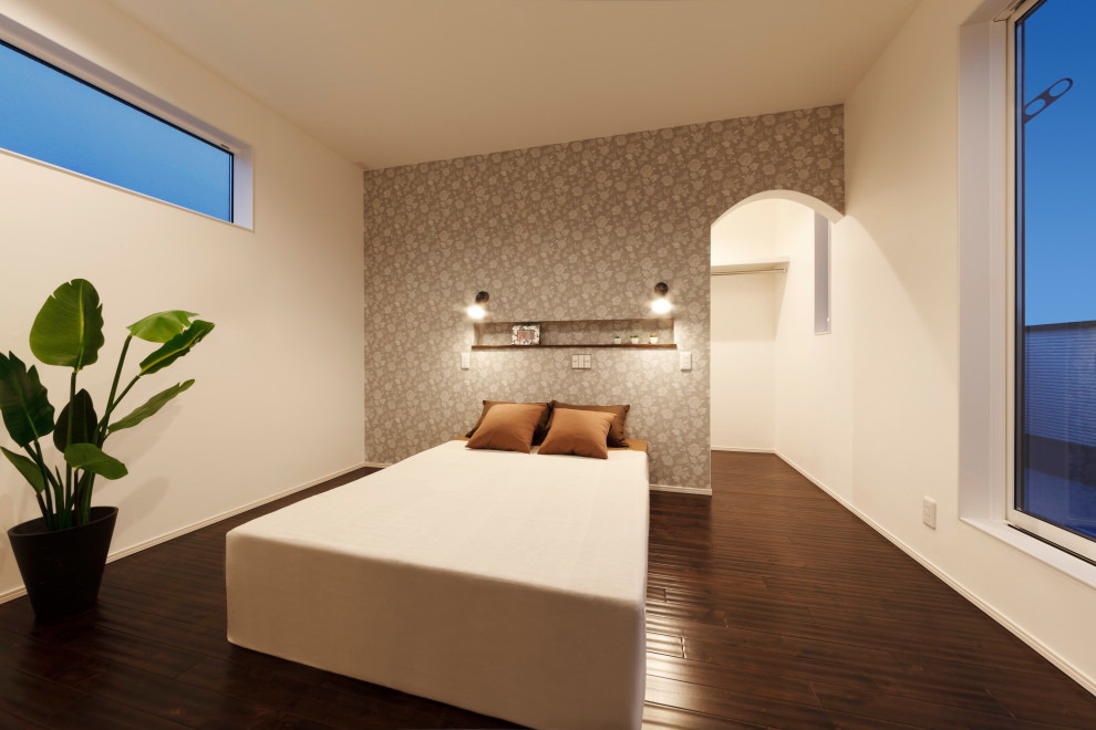 Hauptschlafzimmer mit weißer Wandfarbe, dunklem Holzboden, braunem Boden, Tapetendecke und Tapetenwänden in Sonstige