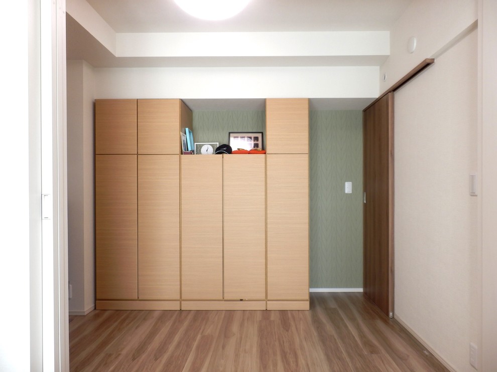 Idéer för ett litet skandinaviskt sovrum, med vita väggar, plywoodgolv och brunt golv