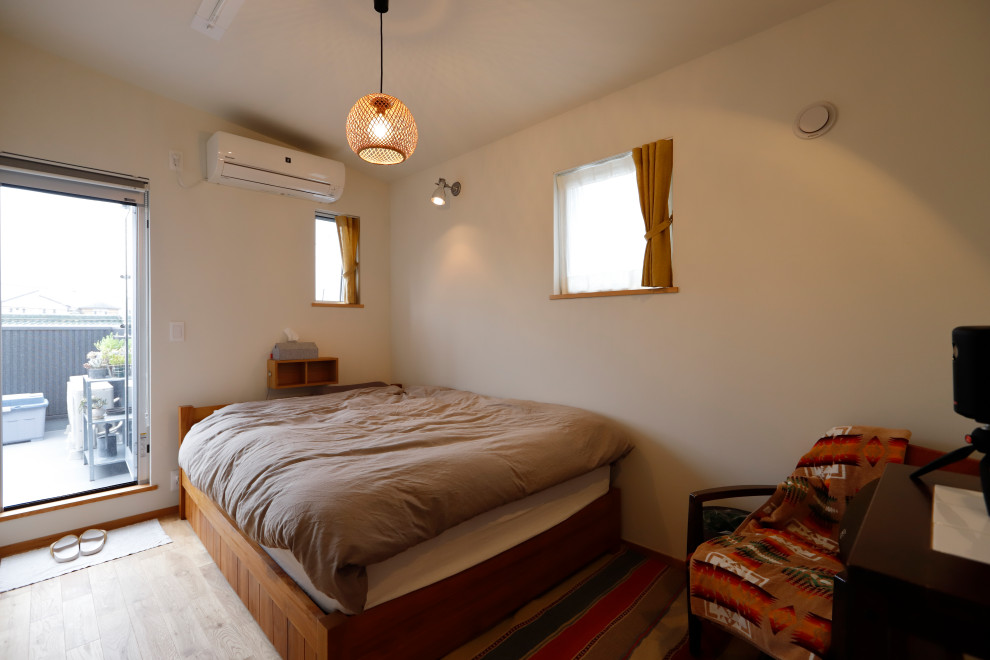 他の地域にあるラスティックスタイルのおしゃれな主寝室 (白い壁、無垢フローリング、茶色い床) のインテリア