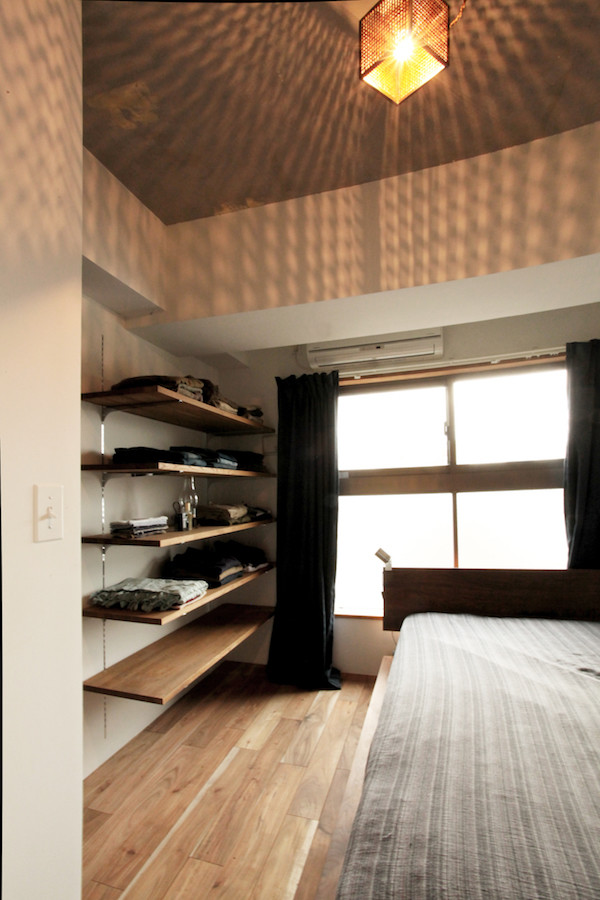 Kleines Asiatisches Hauptschlafzimmer ohne Kamin mit weißer Wandfarbe und braunem Holzboden in Tokio