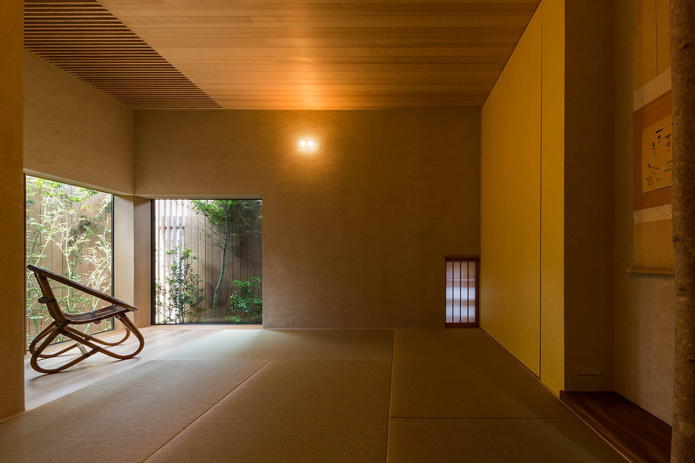 Immagine di una camera da letto etnica con pareti beige e pavimento in tatami