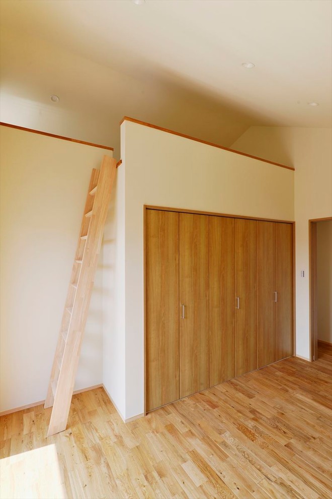 Ispirazione per una camera matrimoniale minimalista con pavimento in legno massello medio