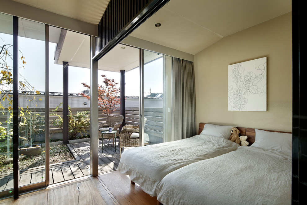 Kleines Asiatisches Schlafzimmer mit beiger Wandfarbe, braunem Holzboden und braunem Boden in Tokio