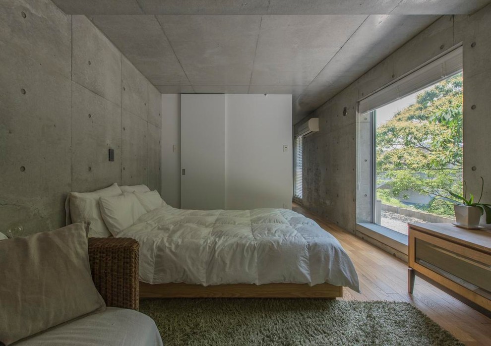 Idée de décoration pour une chambre minimaliste avec un mur gris, un sol en bois brun et un sol marron.