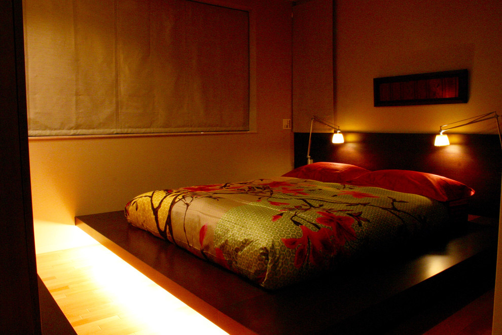 Imagen de dormitorio principal asiático con suelo marrón y paredes beige