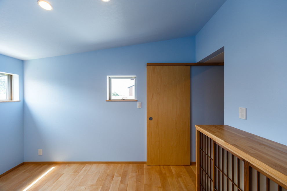 大阪にあるモダンスタイルのおしゃれな主寝室 (青い壁、無垢フローリング、ベージュの床) のレイアウト