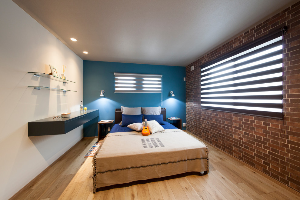 Foto di una camera matrimoniale industriale con pareti blu, pavimento in legno massello medio e pavimento marrone