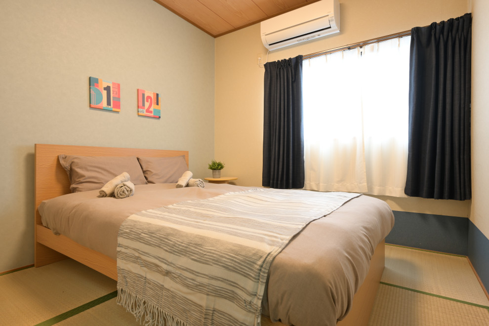 Expansive world-inspired guest bedroom in Osaka with beige walls, tatami flooring and yellow floors.