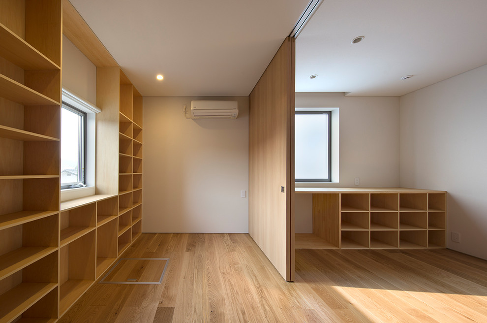 Modelo de dormitorio principal minimalista pequeño con paredes blancas, suelo de contrachapado y suelo beige