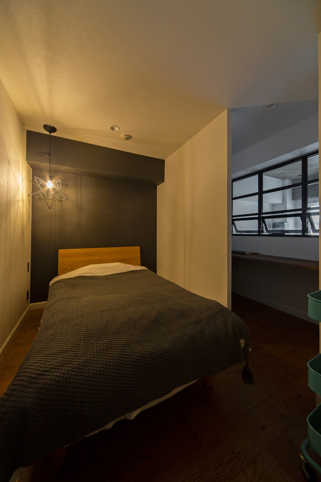 Modelo de dormitorio principal urbano pequeño sin chimenea con paredes grises, suelo de madera en tonos medios y suelo marrón