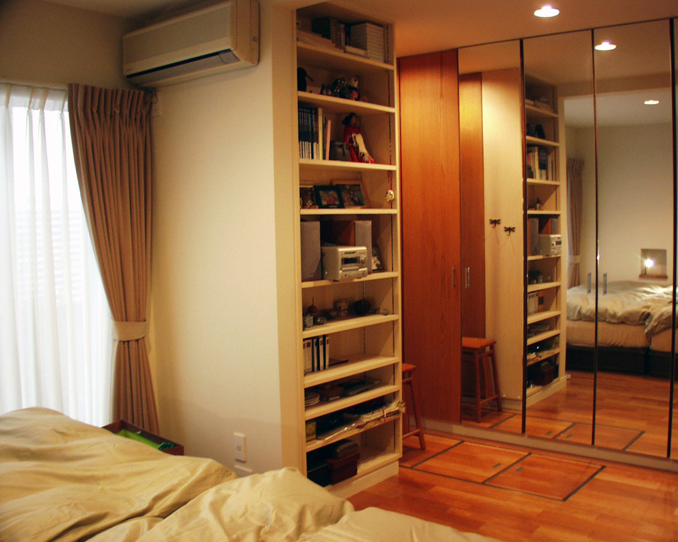 Imagen de dormitorio principal actual con paredes blancas y suelo de madera oscura