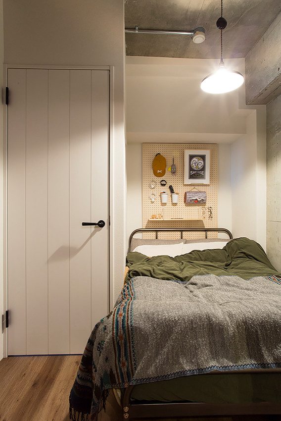 Modelo de dormitorio principal urbano pequeño sin chimenea con paredes blancas, suelo de contrachapado y suelo marrón