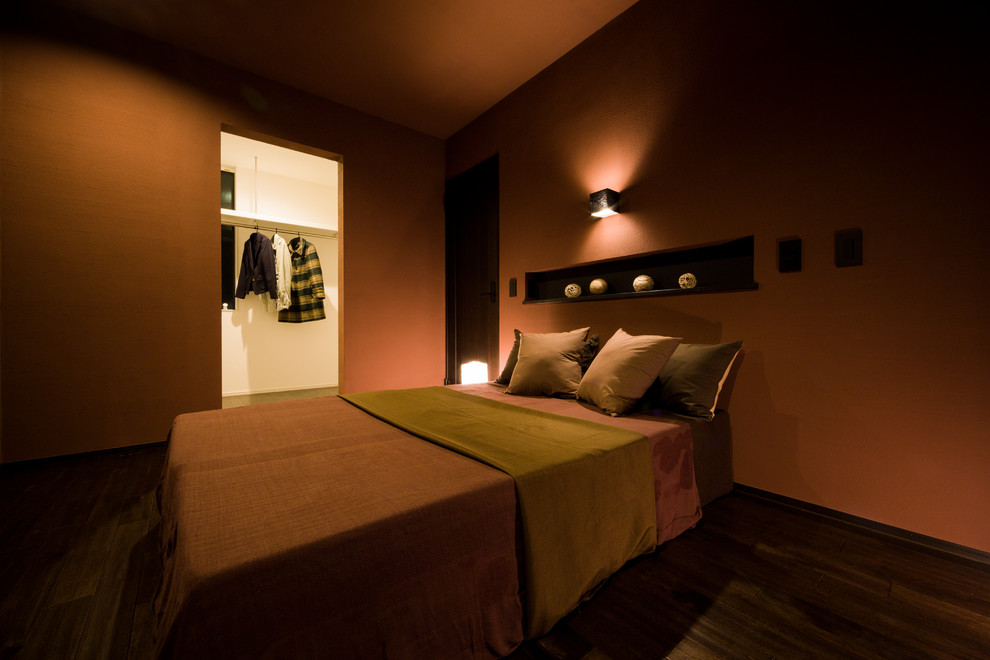 Idée de décoration pour une chambre parentale minimaliste avec un mur marron, parquet foncé et un sol marron.