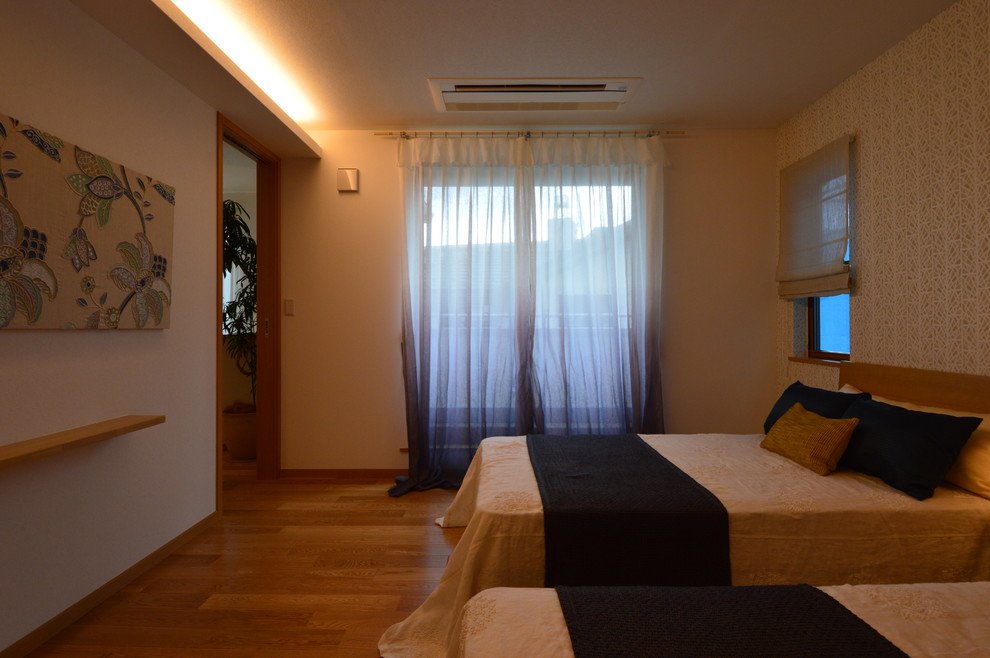 Cette image montre une chambre parentale minimaliste de taille moyenne avec un mur gris, un sol en bois brun et aucune cheminée.