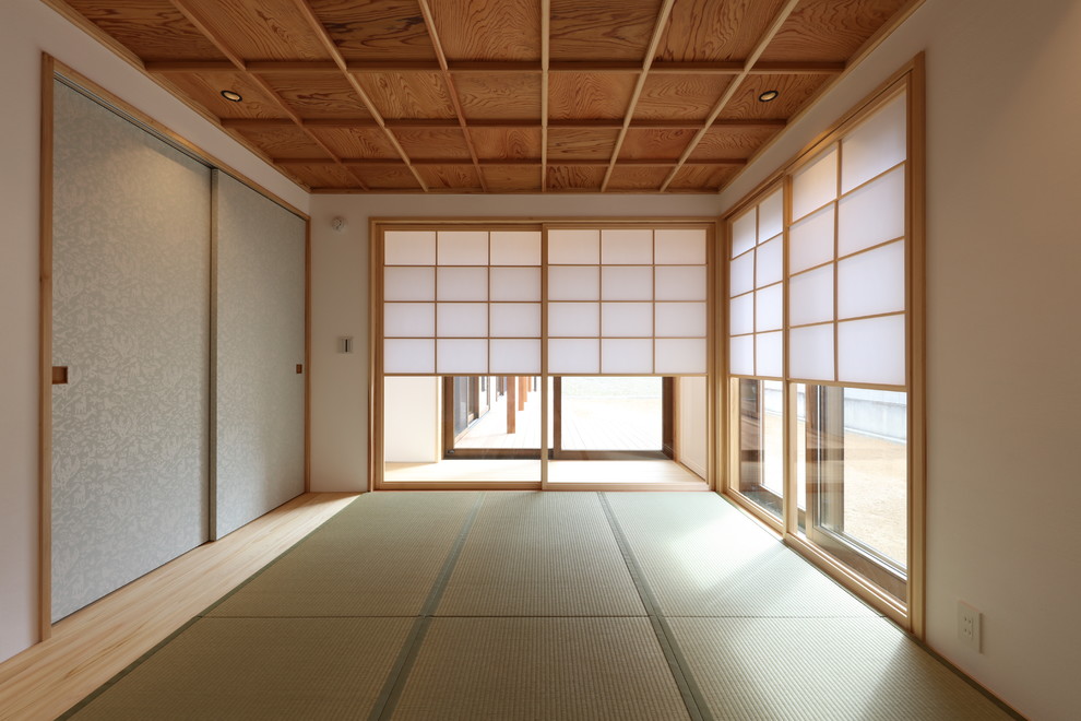 Foto di una camera da letto moderna con pareti bianche, pavimento in tatami, soffitto a cassettoni, stufa a legna e cornice del camino in mattoni