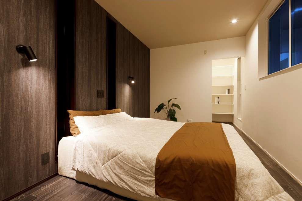 Aménagement d'une chambre parentale rétro avec un mur marron, parquet foncé et un sol marron.