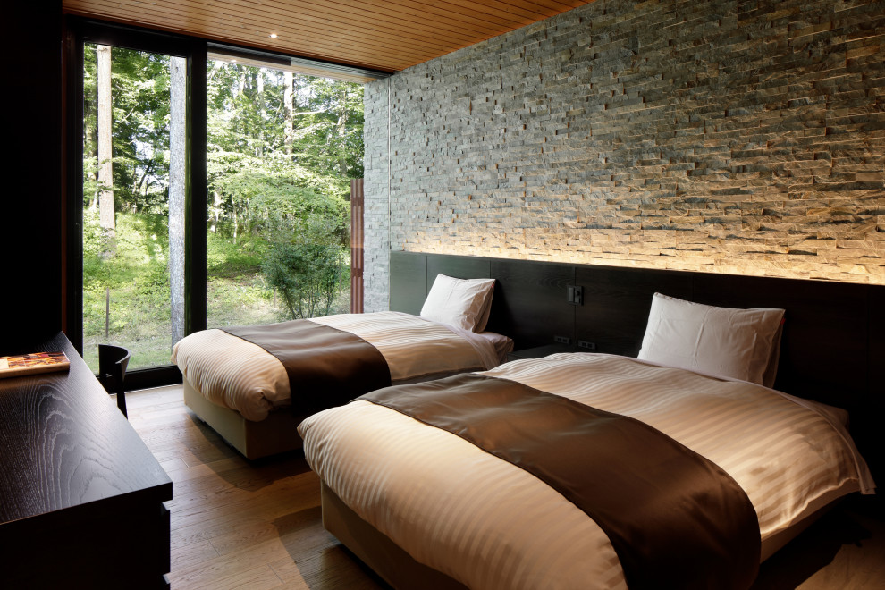 他の地域にあるコンテンポラリースタイルのおしゃれな寝室 (グレーの壁、無垢フローリング、茶色い床) のインテリア