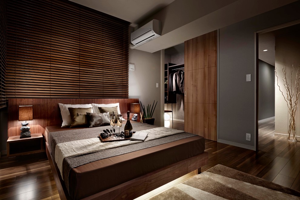 Réalisation d'une chambre asiatique avec un mur gris et un sol en bois brun.