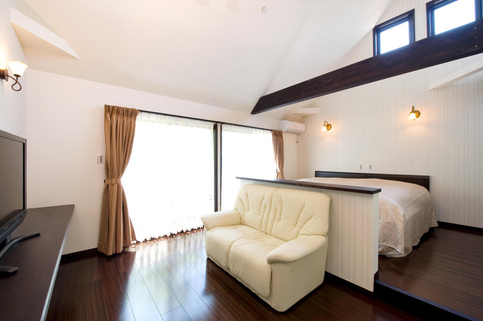 На фото: хозяйская спальня в скандинавском стиле с белыми стенами, темным паркетным полом и коричневым полом с