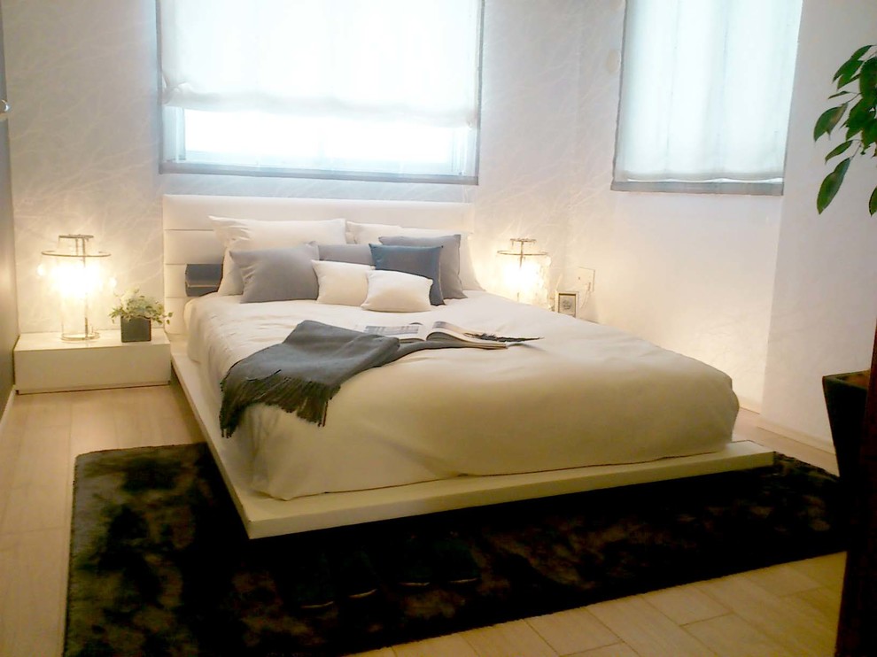 Idéer för nordiska sovrum, med vita väggar, ljust trägolv och brunt golv