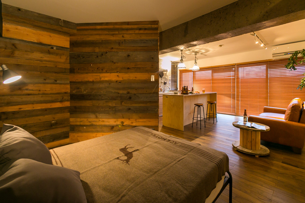 Diseño de dormitorio urbano con paredes blancas, suelo de madera en tonos medios y suelo marrón