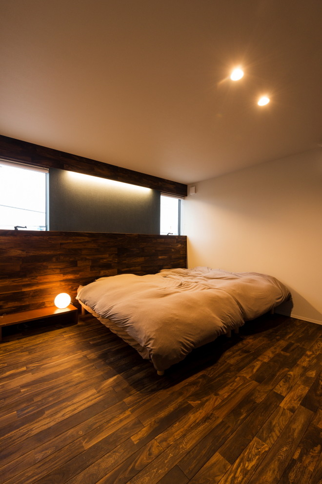 Réalisation d'une chambre minimaliste avec un mur marron, parquet foncé et un sol marron.
