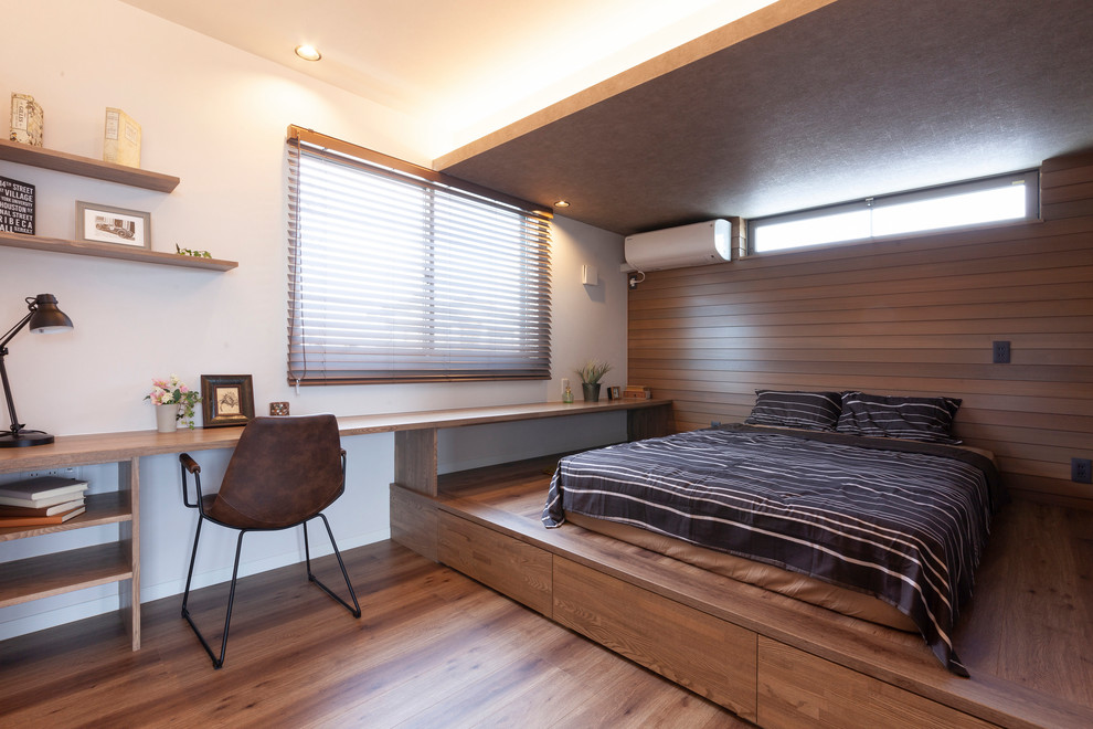 Modelo de dormitorio nórdico con paredes blancas, suelo de madera en tonos medios y suelo marrón