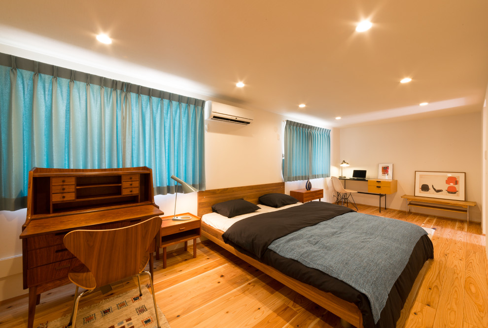 Inspiration pour une chambre minimaliste avec un sol en bois brun et un sol marron.