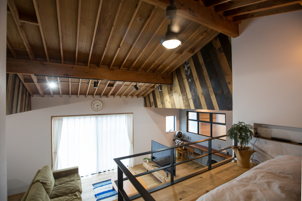 Diseño de dormitorio tipo loft industrial pequeño sin chimenea con paredes blancas, suelo de madera clara y suelo beige