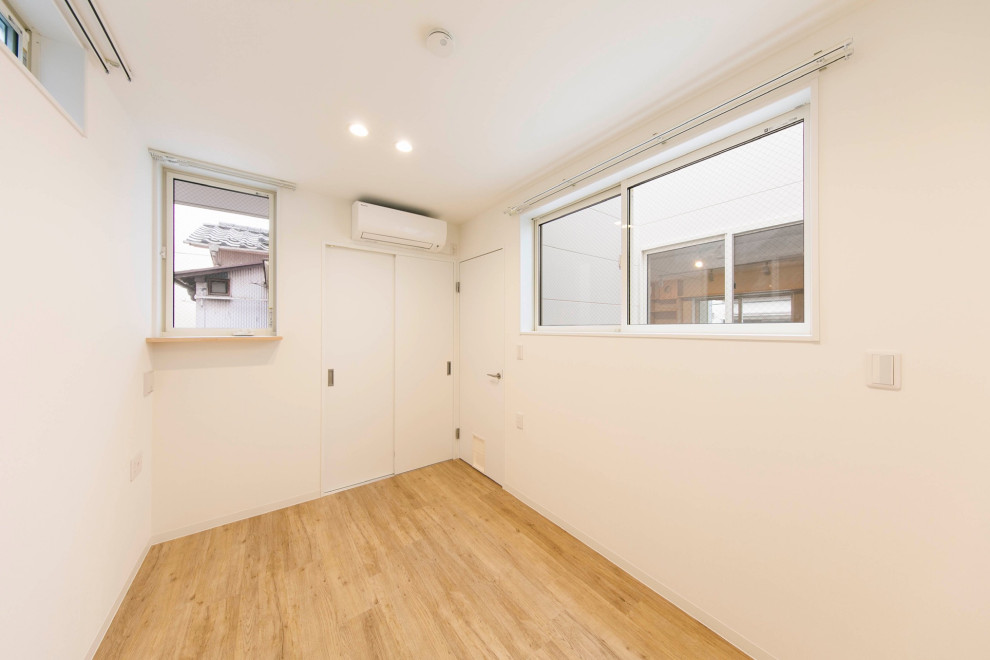 東京23区にある小さな北欧スタイルのおしゃれな主寝室 (白い壁、淡色無垢フローリング、ベージュの床、クロスの天井、壁紙)