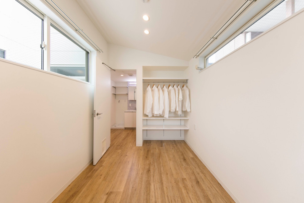 Diseño de dormitorio principal nórdico pequeño con paredes blancas, suelo de madera clara, suelo beige, papel pintado y papel pintado