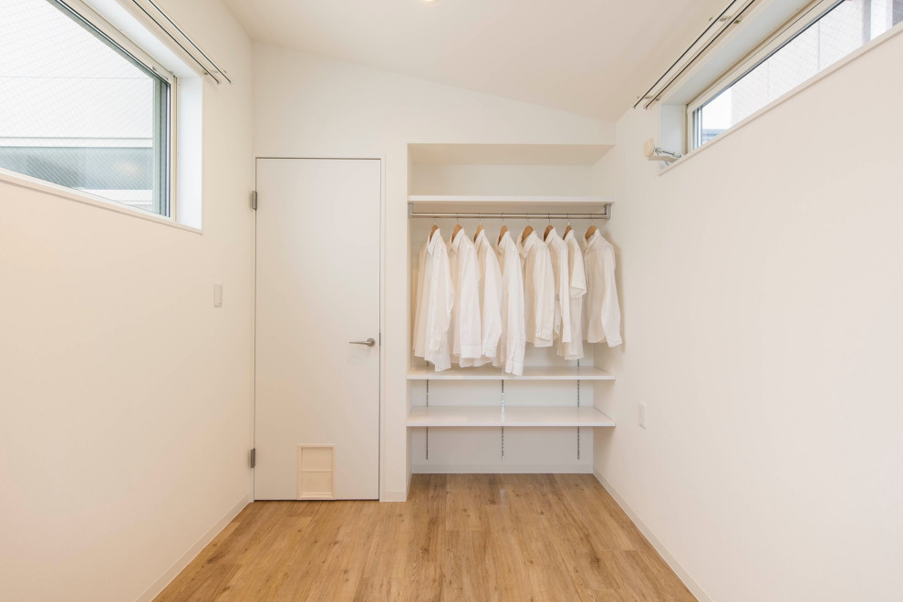 Foto de dormitorio principal escandinavo pequeño con paredes blancas, suelo de madera clara, suelo beige, papel pintado y papel pintado
