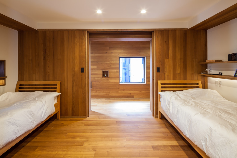 Ejemplo de dormitorio de estilo zen con paredes blancas y suelo de madera en tonos medios