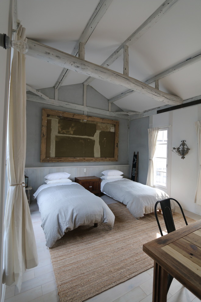 Idée de décoration pour une chambre d'amis champêtre de taille moyenne avec un mur beige et parquet clair.