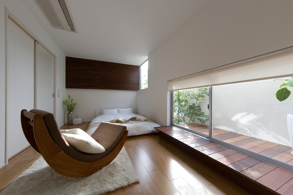 Modelo de dormitorio principal y blanco de estilo zen sin chimenea con paredes blancas, papel pintado, papel pintado, suelo de contrachapado y suelo marrón