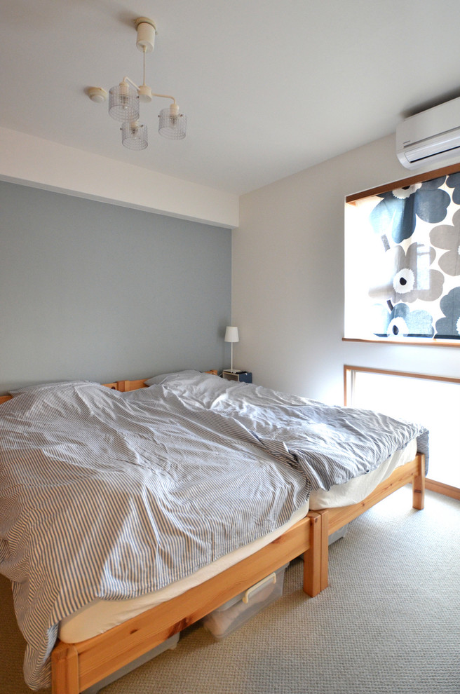 Inredning av ett minimalistiskt sovrum, med flerfärgade väggar, heltäckningsmatta och grått golv