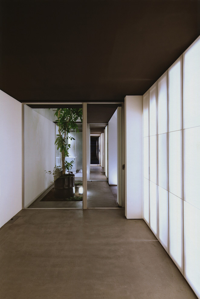 Свежая идея для дизайна: маленькая хозяйская спальня в стиле модернизм с белыми стенами, бетонным полом и черным полом без камина для на участке и в саду - отличное фото интерьера