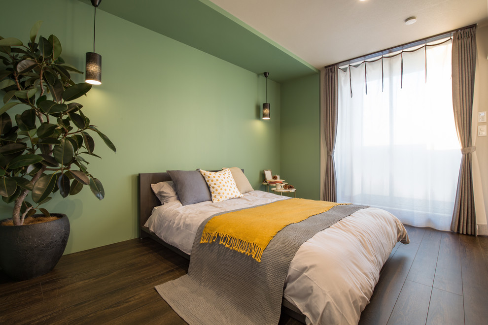 Bild på ett sovrum, med mörkt trägolv, brunt golv och gröna väggar