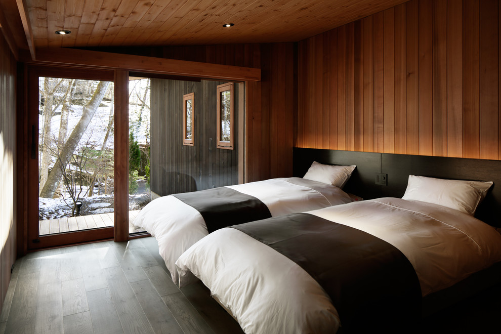 На фото: гостевая спальня (комната для гостей) в стиле рустика с коричневыми стенами, темным паркетным полом и черным полом