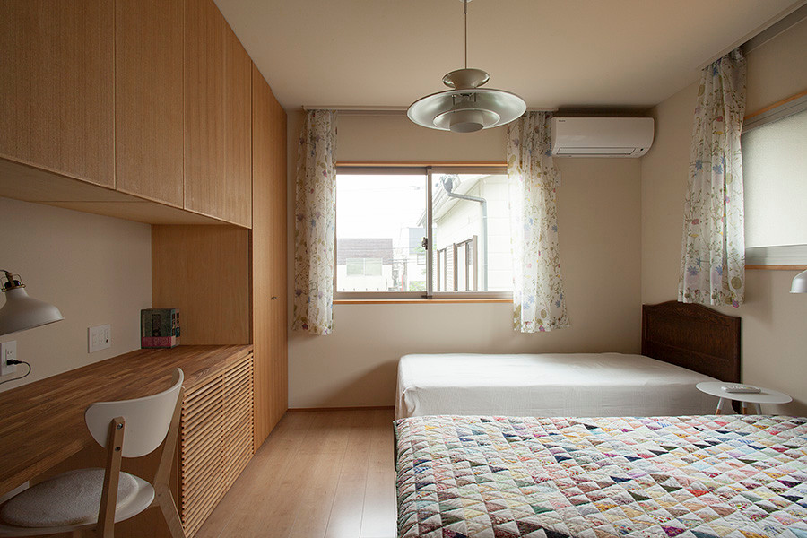 На фото: хозяйская спальня среднего размера в стиле кантри с белыми стенами, полом из фанеры, подвесным камином и бежевым полом