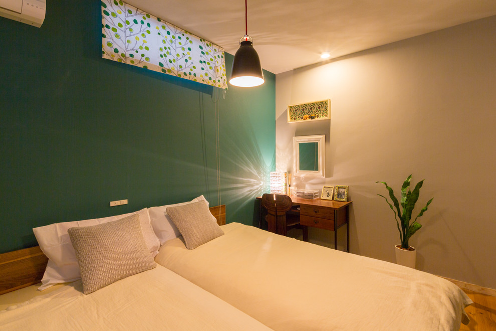 他の地域にある中くらいな北欧スタイルのおしゃれな主寝室 (緑の壁、無垢フローリング、暖炉なし、茶色い床)