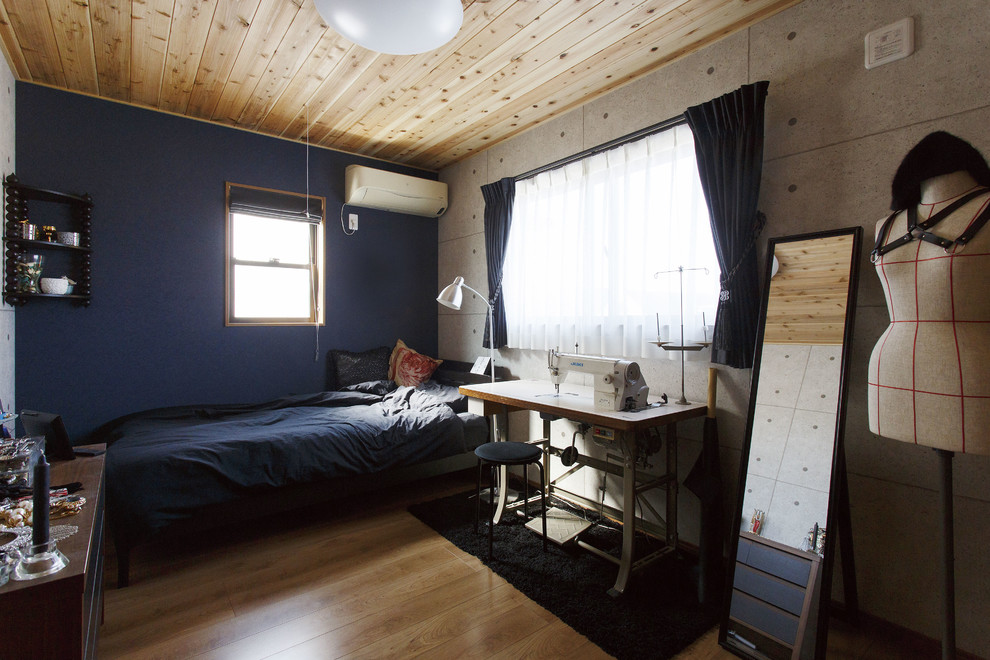 Modelo de dormitorio urbano con suelo de madera en tonos medios y paredes azules