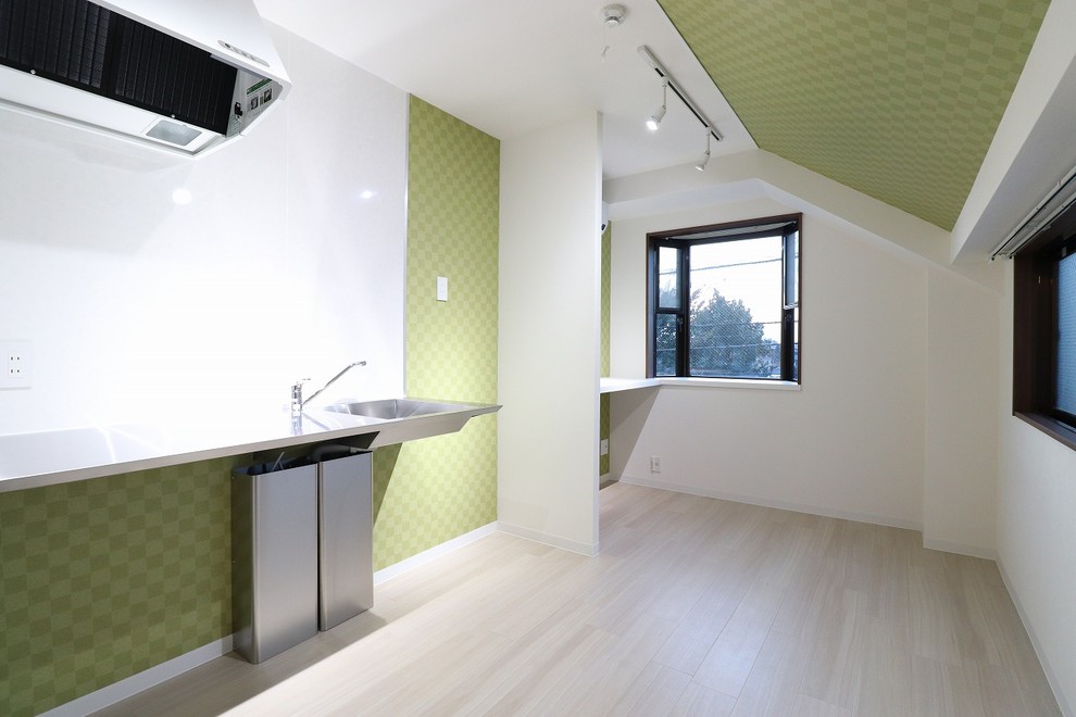 Immagine di una piccola camera matrimoniale industriale con pareti verdi e pavimento bianco