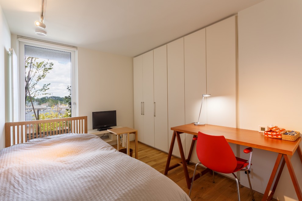 Idee per una piccola camera da letto moderna con pareti bianche, pavimento in legno massello medio e pavimento marrone