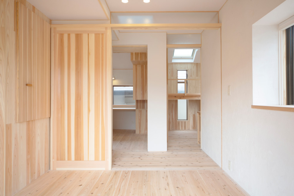 Idées déco pour une petite chambre parentale scandinave avec un mur beige, parquet clair, un sol beige et boiseries.