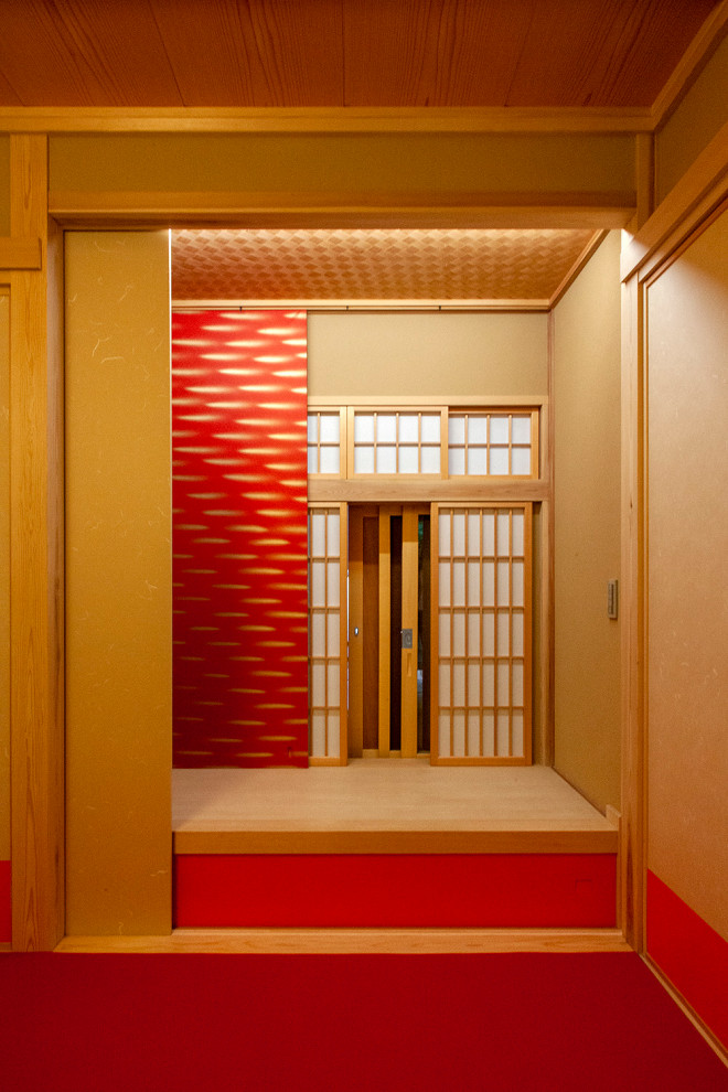 На фото: гостевая спальня среднего размера, (комната для гостей) в восточном стиле с красными стенами, татами и красным полом без камина