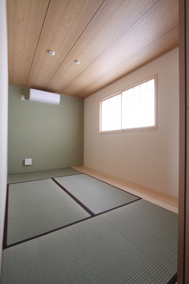 Cette image montre une chambre d'amis asiatique de taille moyenne avec un mur multicolore, un sol de tatami et un sol vert.