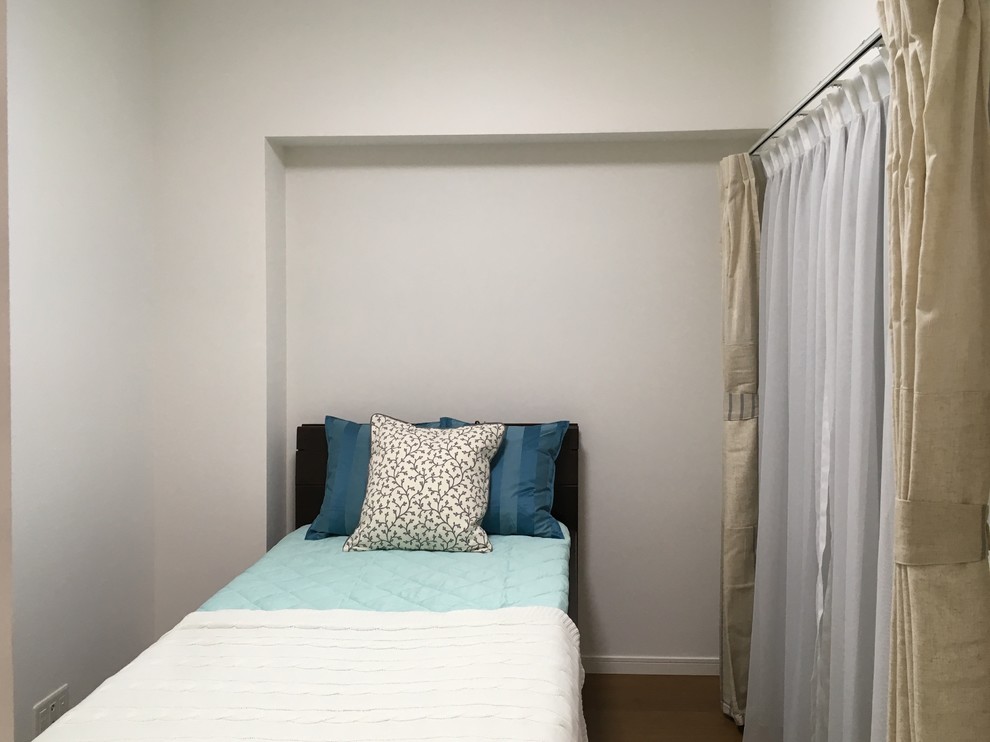 Kleines Modernes Hauptschlafzimmer ohne Kamin mit weißer Wandfarbe, Sperrholzboden und braunem Boden in Yokohama
