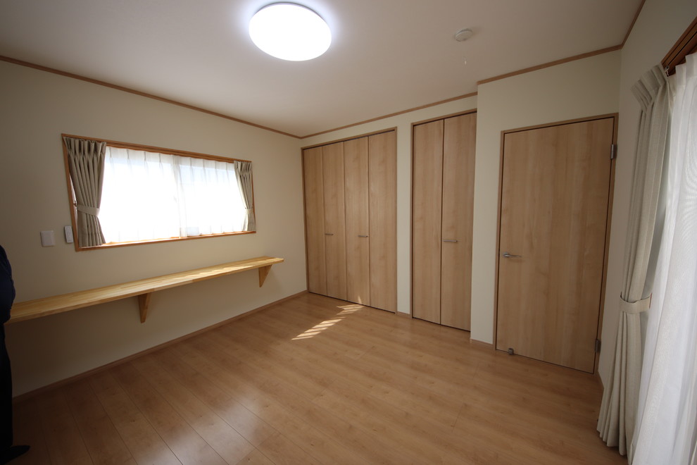 Mittelgroßes Modernes Hauptschlafzimmer mit beiger Wandfarbe, gebeiztem Holzboden und braunem Boden in Sonstige