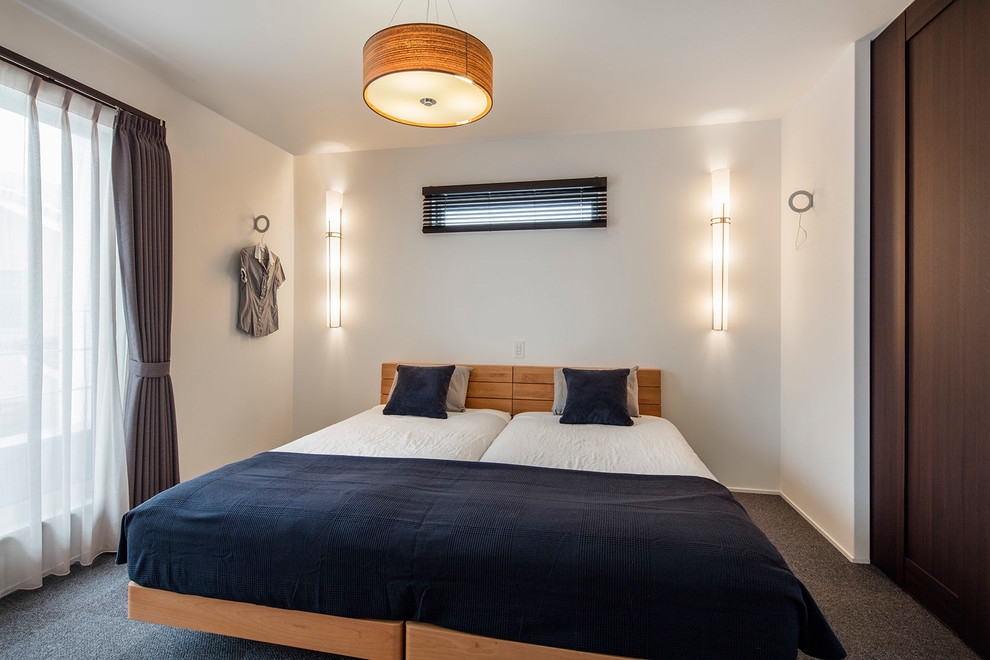 Modelo de dormitorio escandinavo con paredes blancas, moqueta y suelo gris